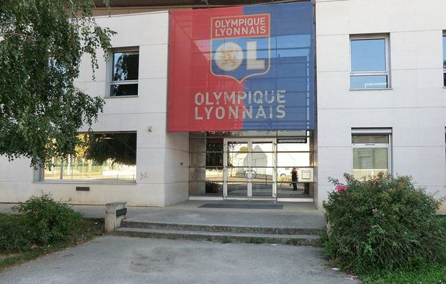 Entrée du bâtiment du centre Tola Vologe, avec une bâche aux couleurs de l'Olympique lyonnais.