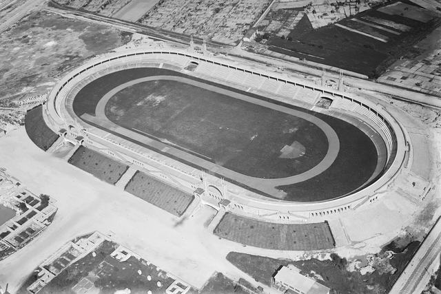 Vue aérienne du stade de Gerland dans les années 1920 : un ovale de béton entourant une pelouse, une piste d'athlétisme et une piste cycliste.