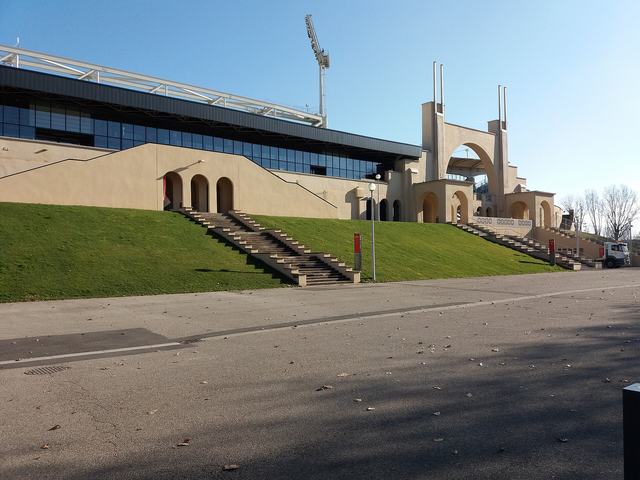 Les entrées principales du stade de Gerland côté sud, avec l'arche monumentale en béton et l'escalier sur le talus engazonné.